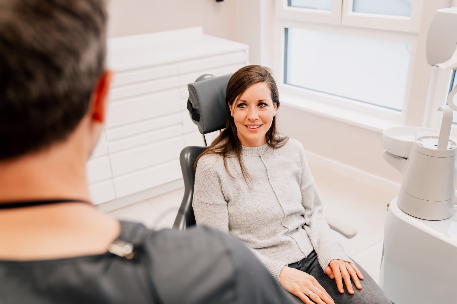 Entspannte Patientin sitzt auf dem Behandlungsstuhl